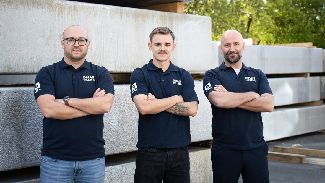 The BIKAR team at the Zlín office in the Czech Republic standing in front of large aluminum blocks.