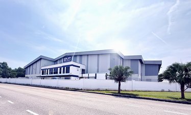 Außenaufnahme des Produktionsstandortes von BIKAR METALS in Malaysia. Großes Gebäude mit Firmenlogo an der Fassade.