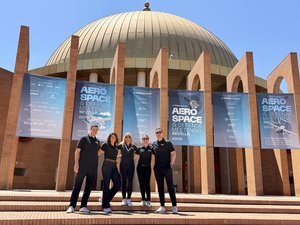 Mitarbeitende von BIKAR stehen vor dem Messeeingang zur Luftfahrtmesse in Sevilla.